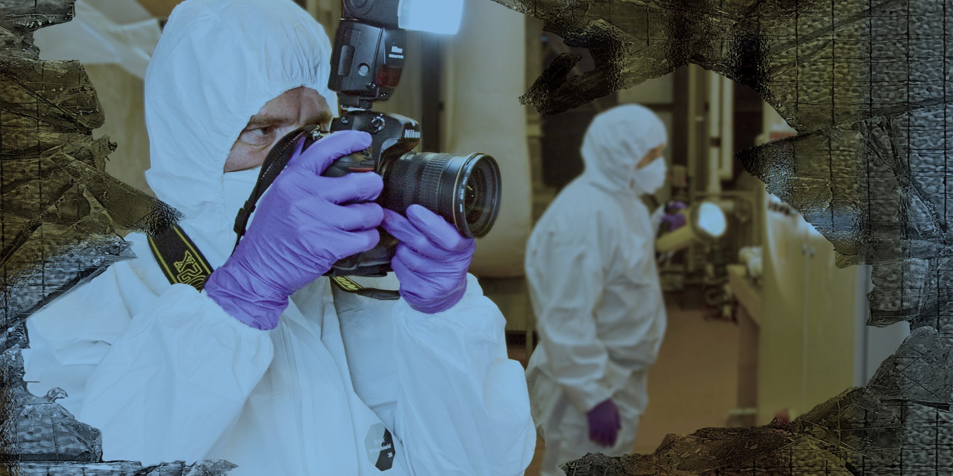 man in ppe taking a photo at a forensics scene
