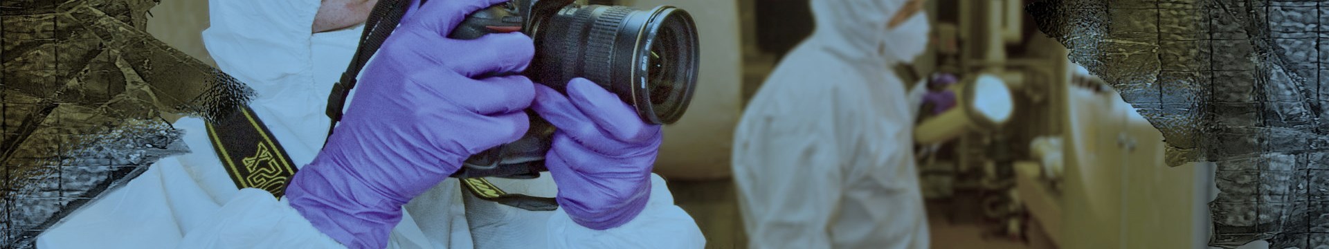 man in ppe taking a photo at a forensics scene