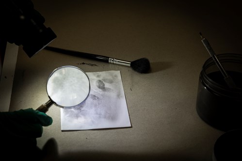 Magnifying glass and fingerprints on white paper